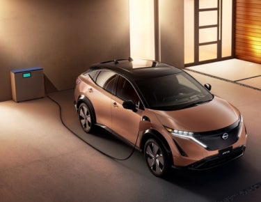 Nissan ARIYA plugged-in and charging outside a home | Andy Mohr Nissan in Indianapolis IN